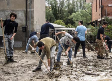 Ragazzi spalano il fango dopo l'alluvione in Romagna